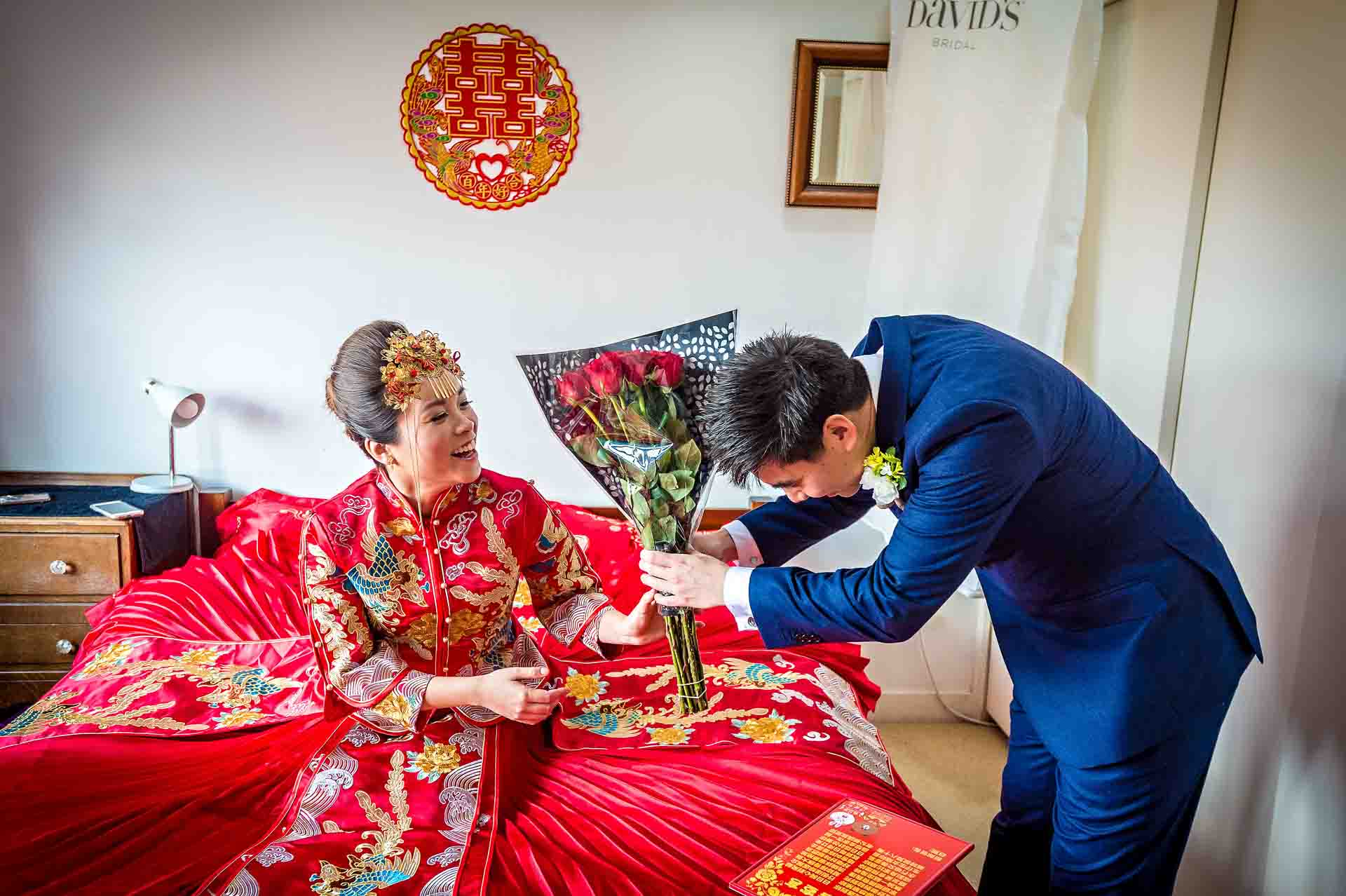 Chinese wedding acceptance with groom presenting bride a bunch of red roses