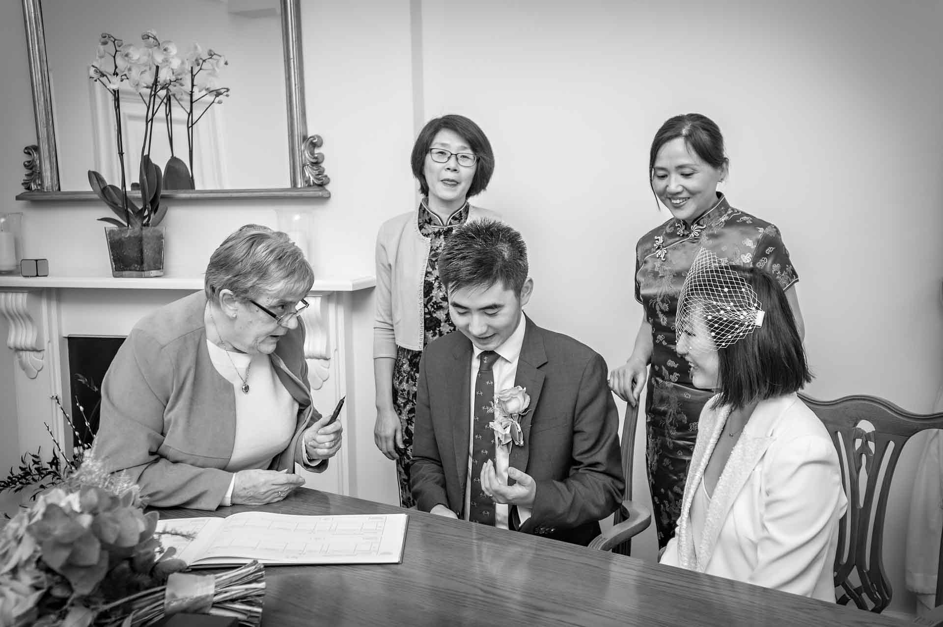 The newly-weds sign their wedding register in Woolwich