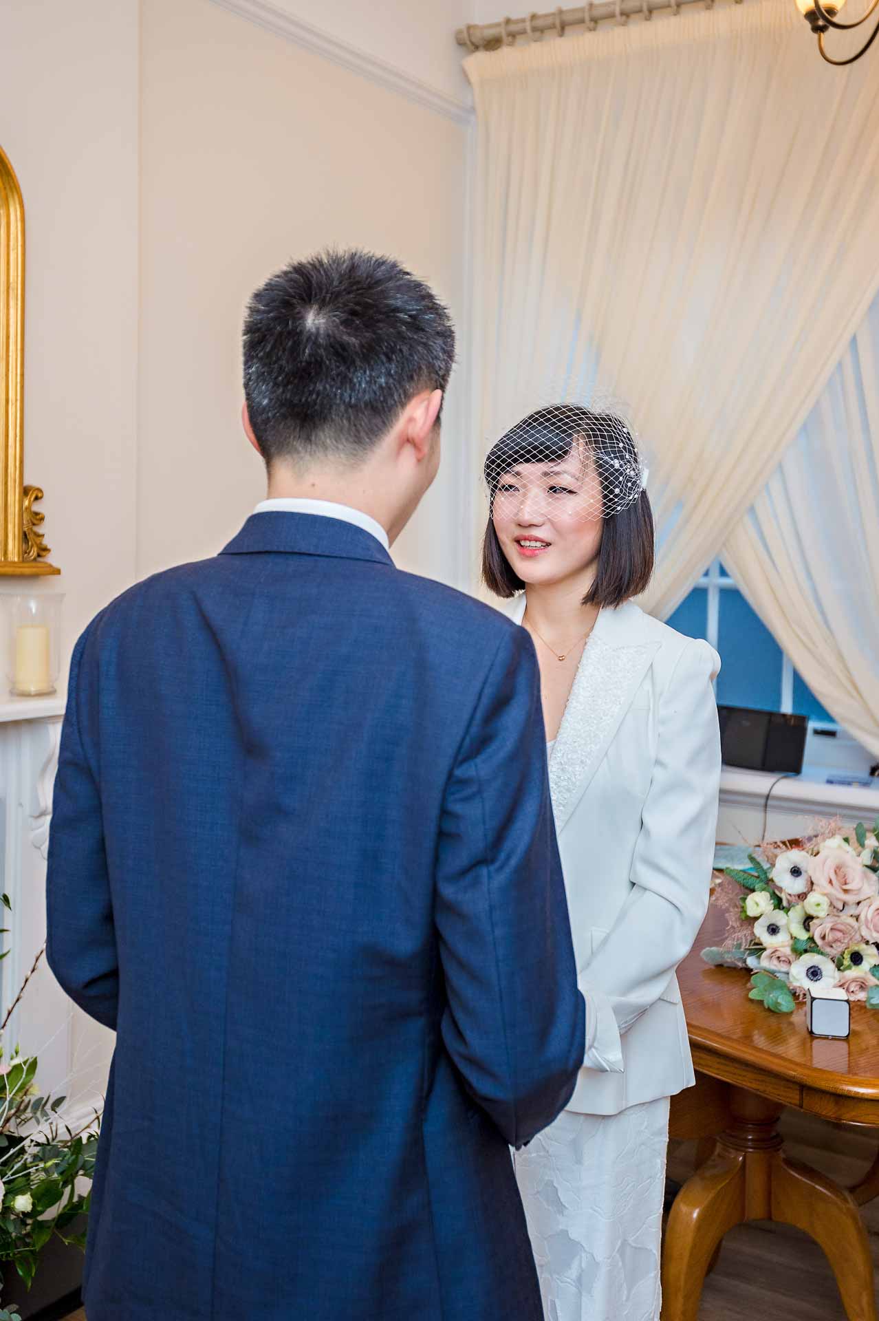 Chinese bride looking at groom during wedding ceremony