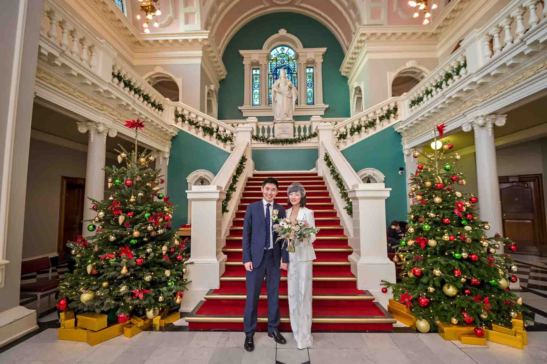 The newly-weds pose in the Victorian Hall after their Woolwich Town Hall Wedding at Christmas time