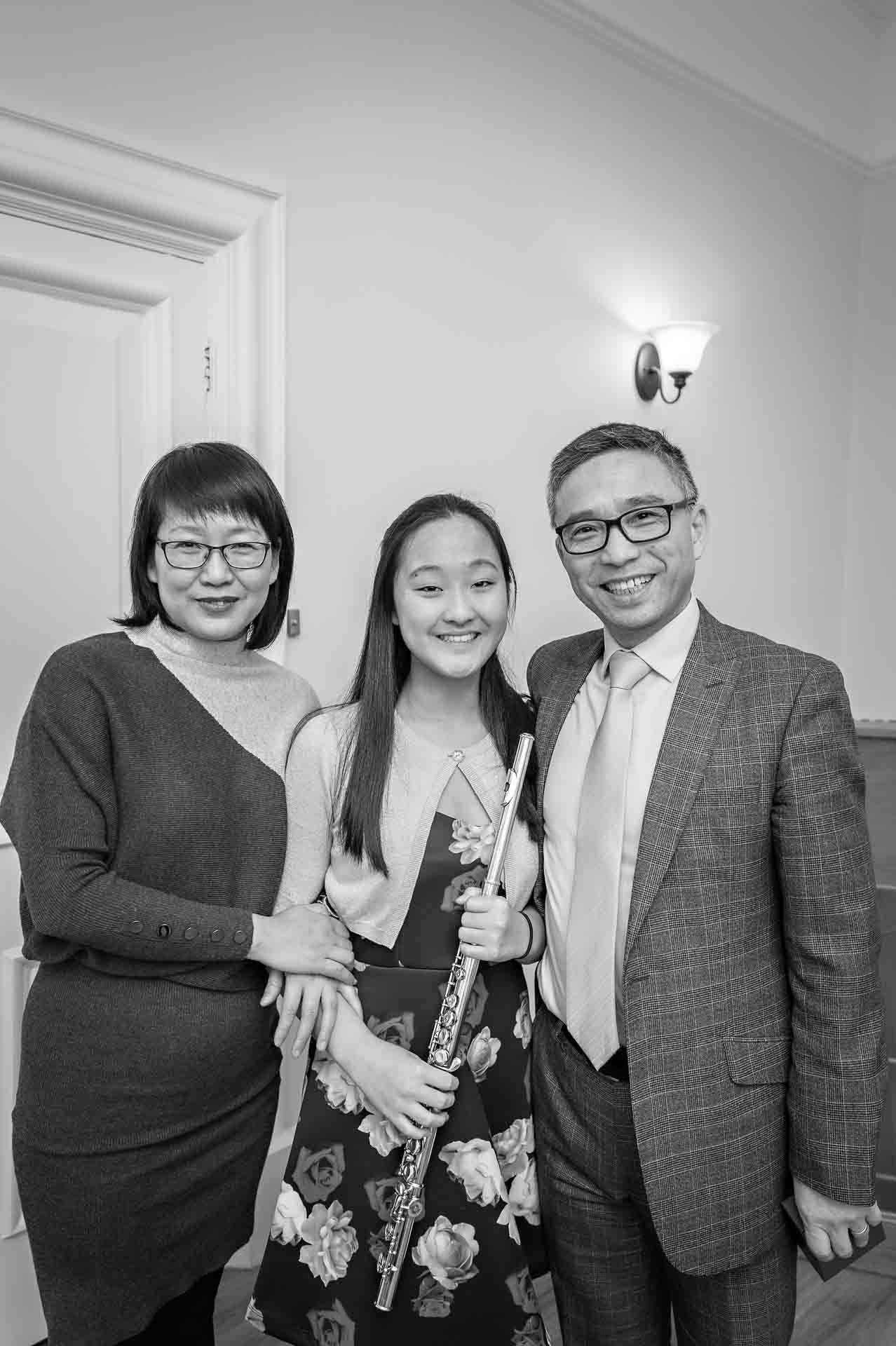 Family with girl holding flute pose for wedding photo