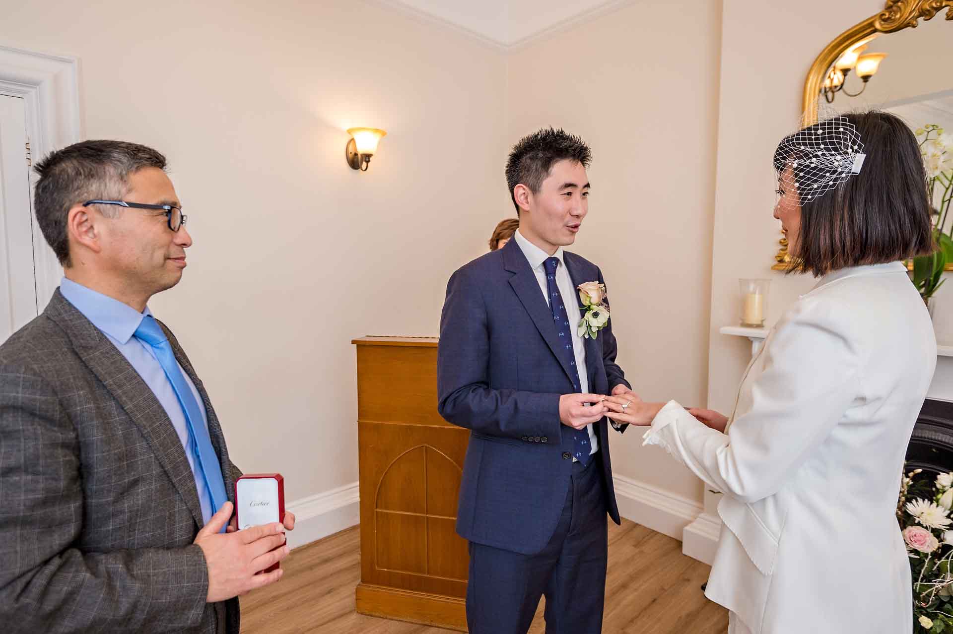 Rings exchange at wedding with father of the groom watching