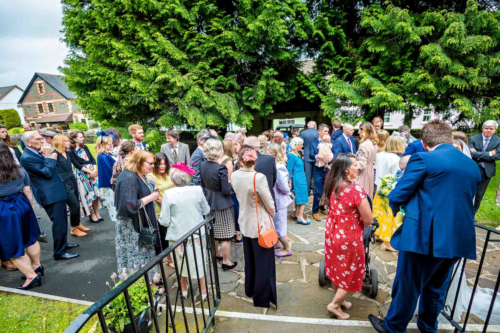 Lots of wedding guests milling around outside church after wedding ceremony