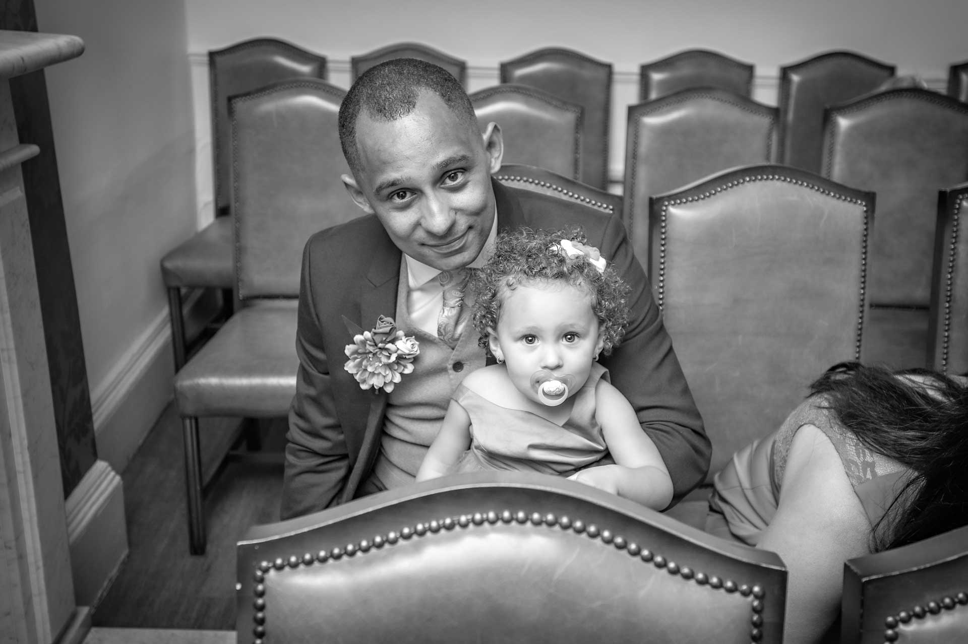 Father and baby daughter sit in register office of Southwark at wedding