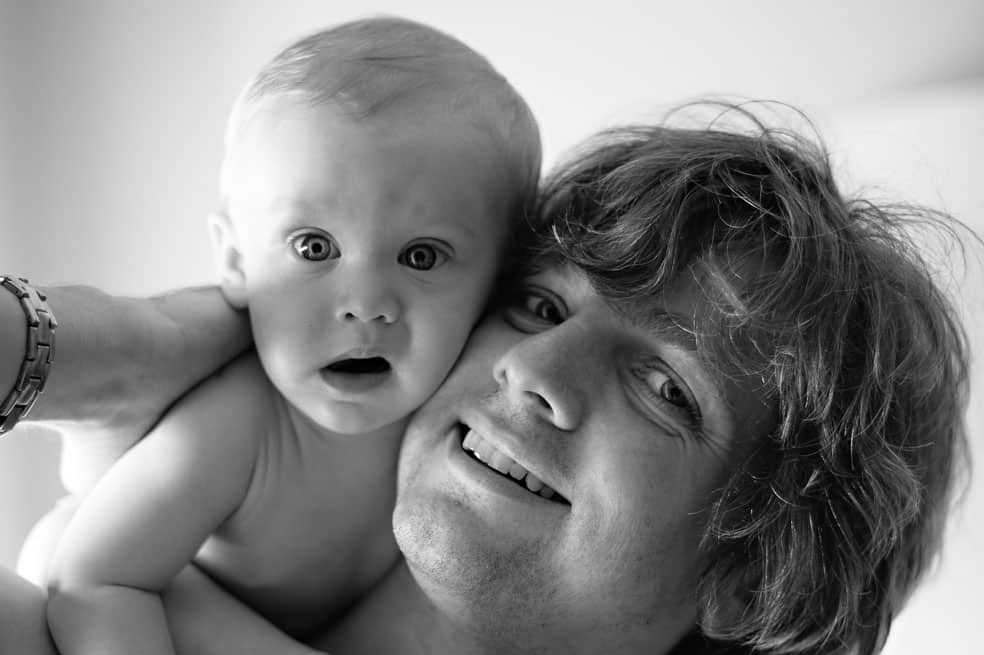 Guy Milnes with Baby Son Looking Surprised