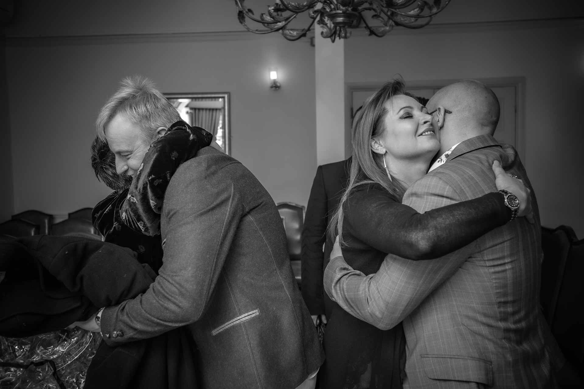 Newly-wedded couple hugging guests at Southwark Register Office wedding