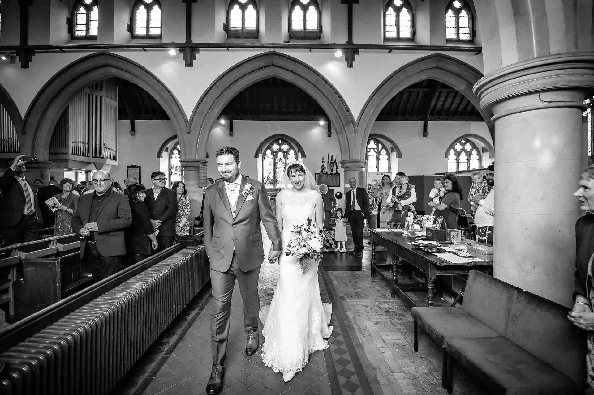 Happy couple walking out of St Martin's Church in Caerphilly
