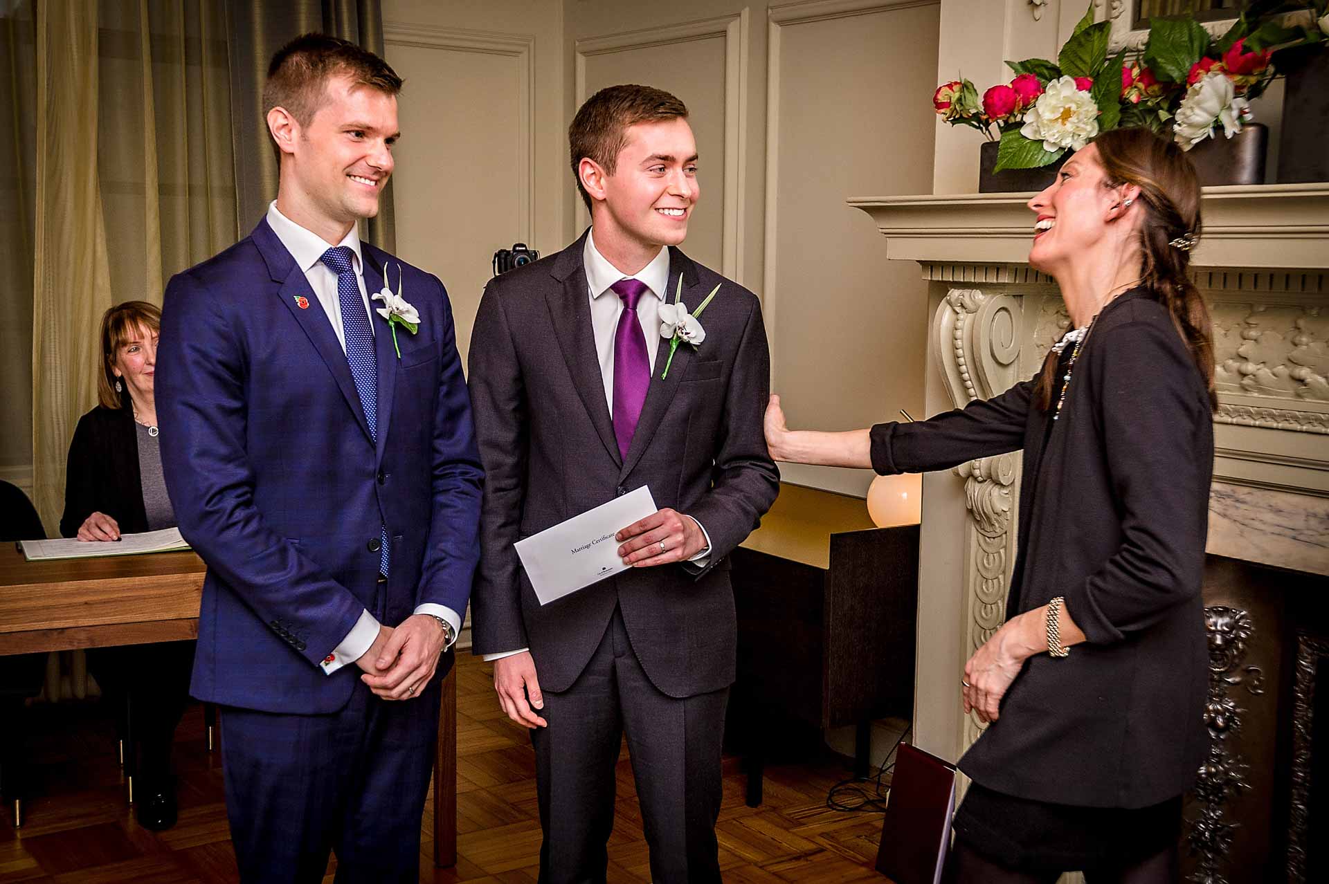 Register holding arm of groom at gay wedding