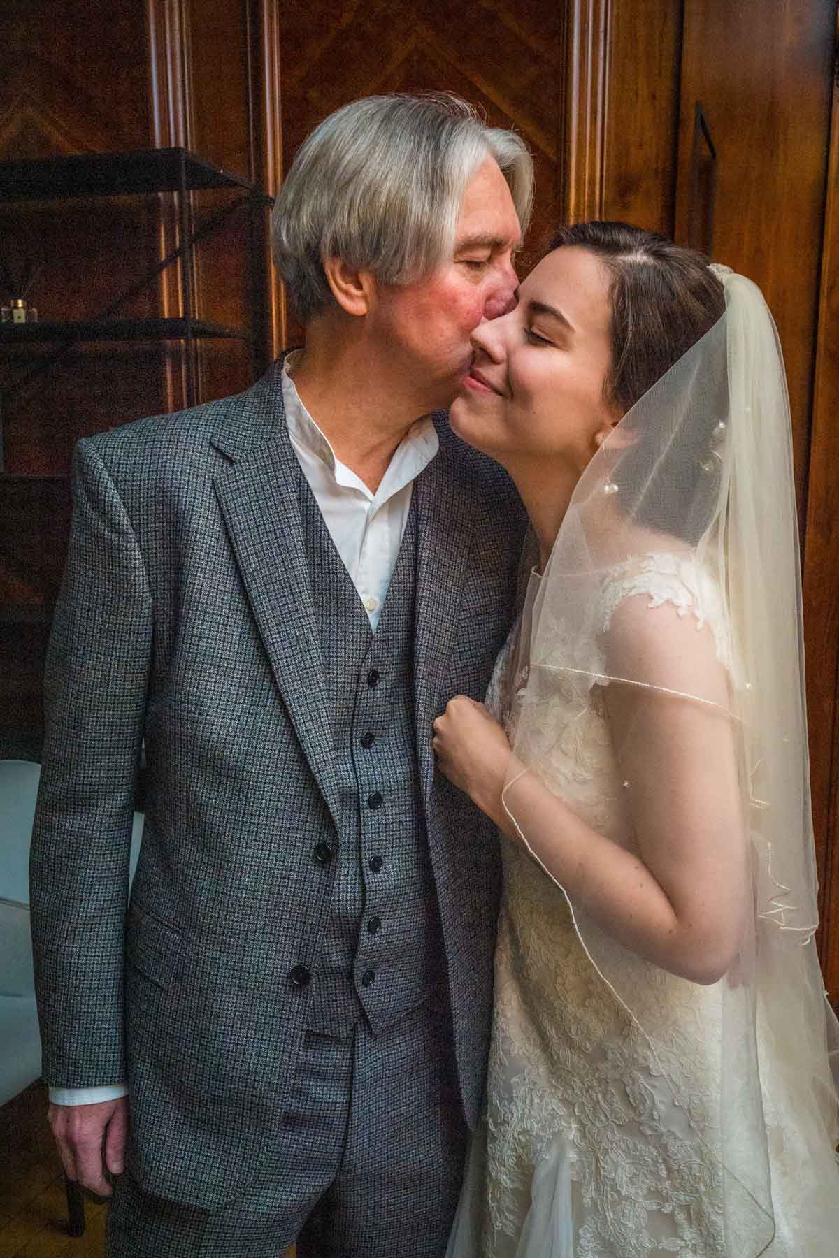 The father of the bride kisses her at a short wedding in London