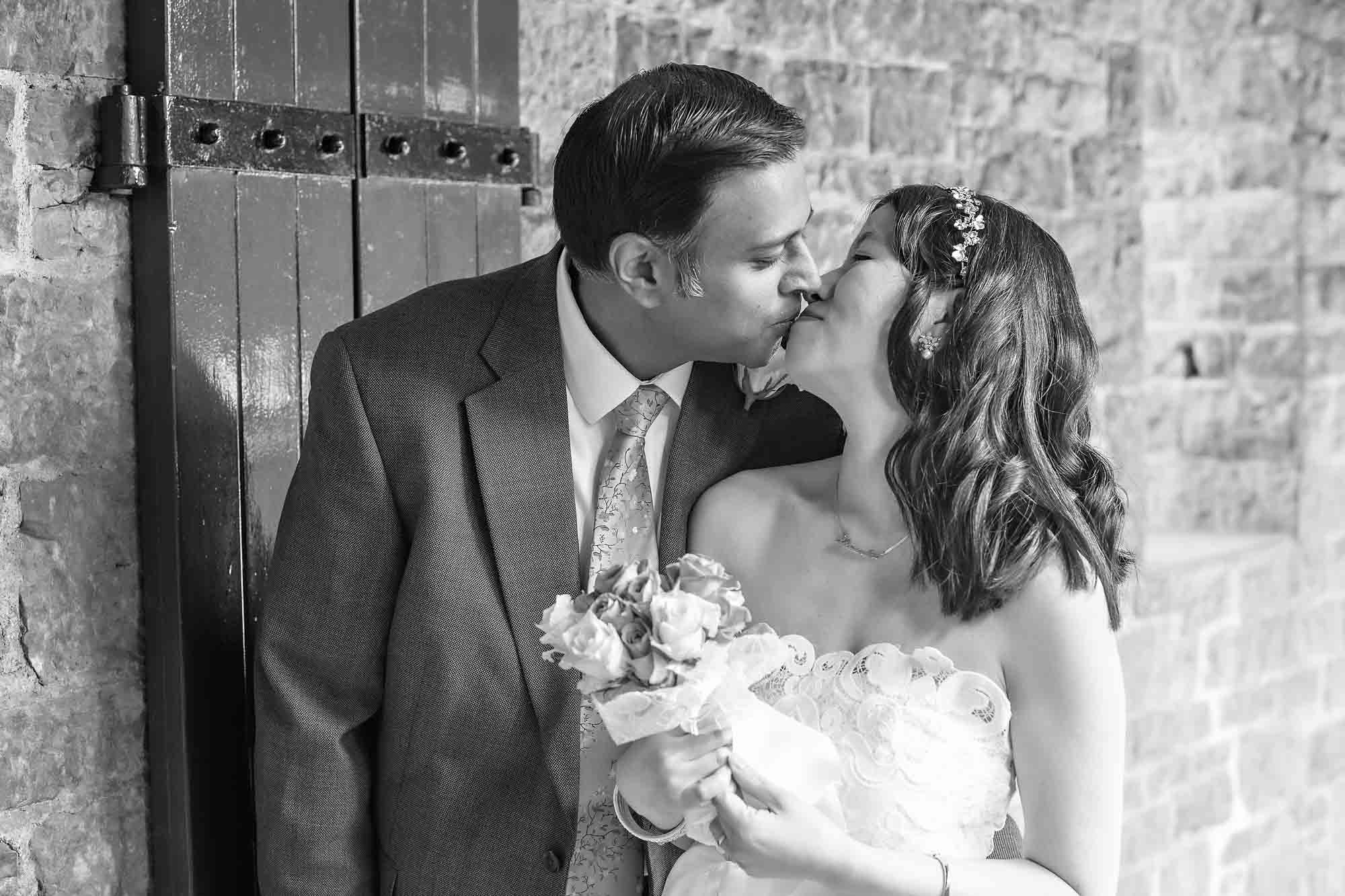 Black and white photo of newlyweds kissing at a Castell Coch wedding, Cardiff