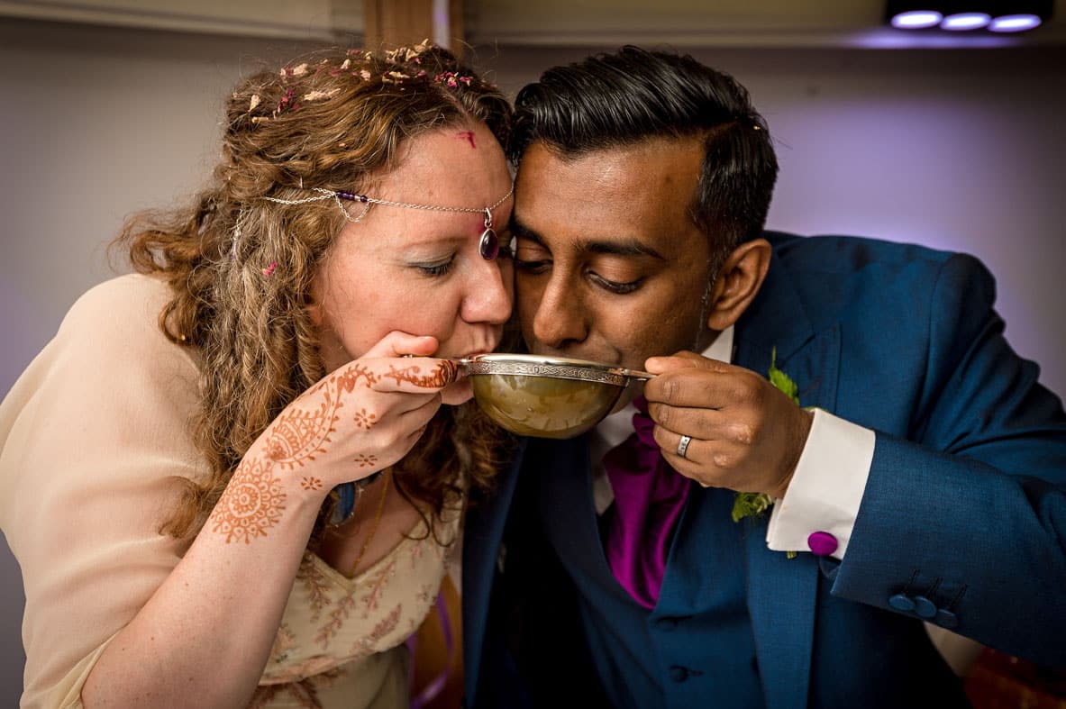 Newly-weds Drinking from the Same Cup at Wedding in Cardiff
