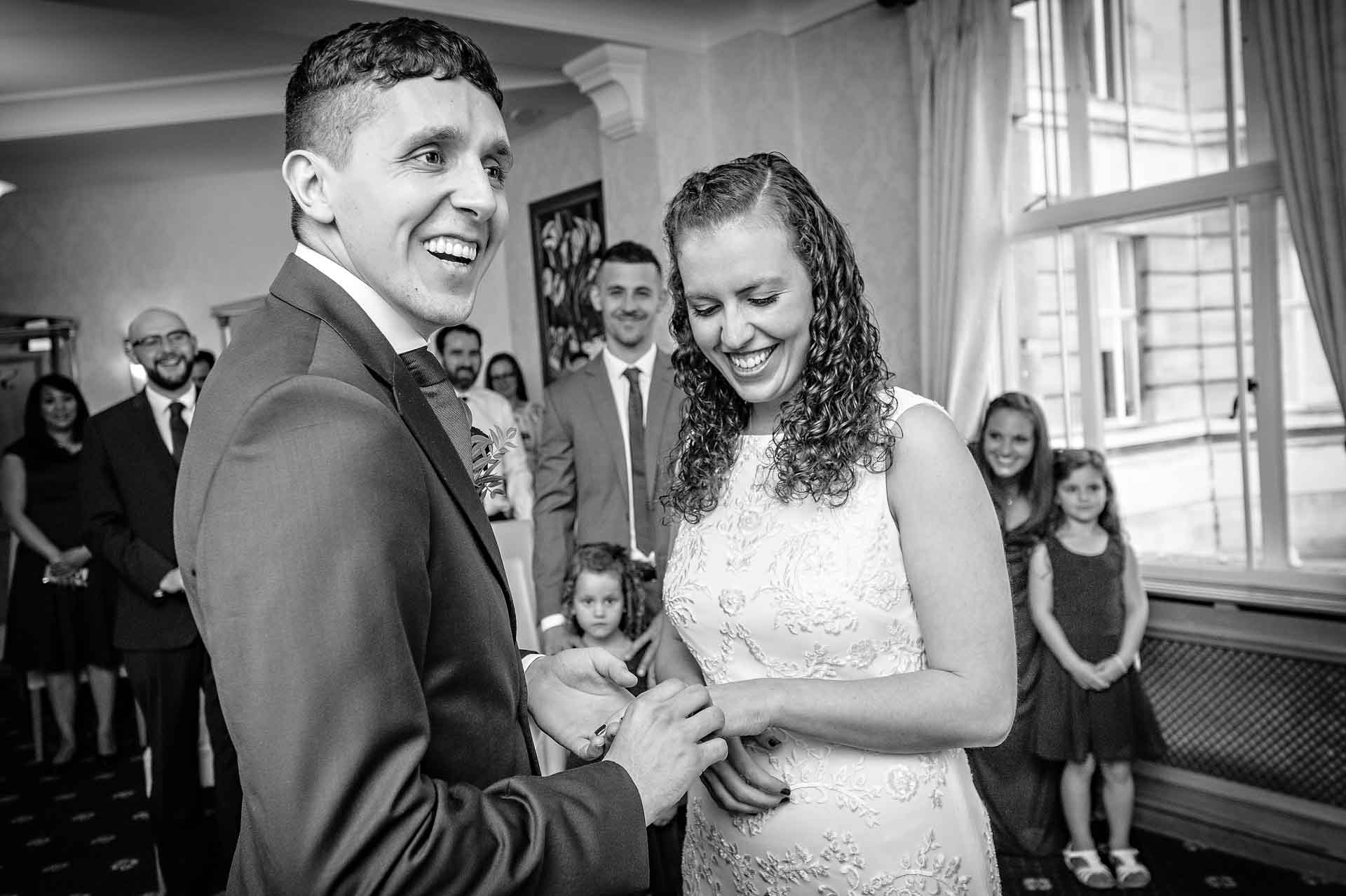 Groom Laughing as he Places Ring on Bride's Finger at Wandsworth Town Hall