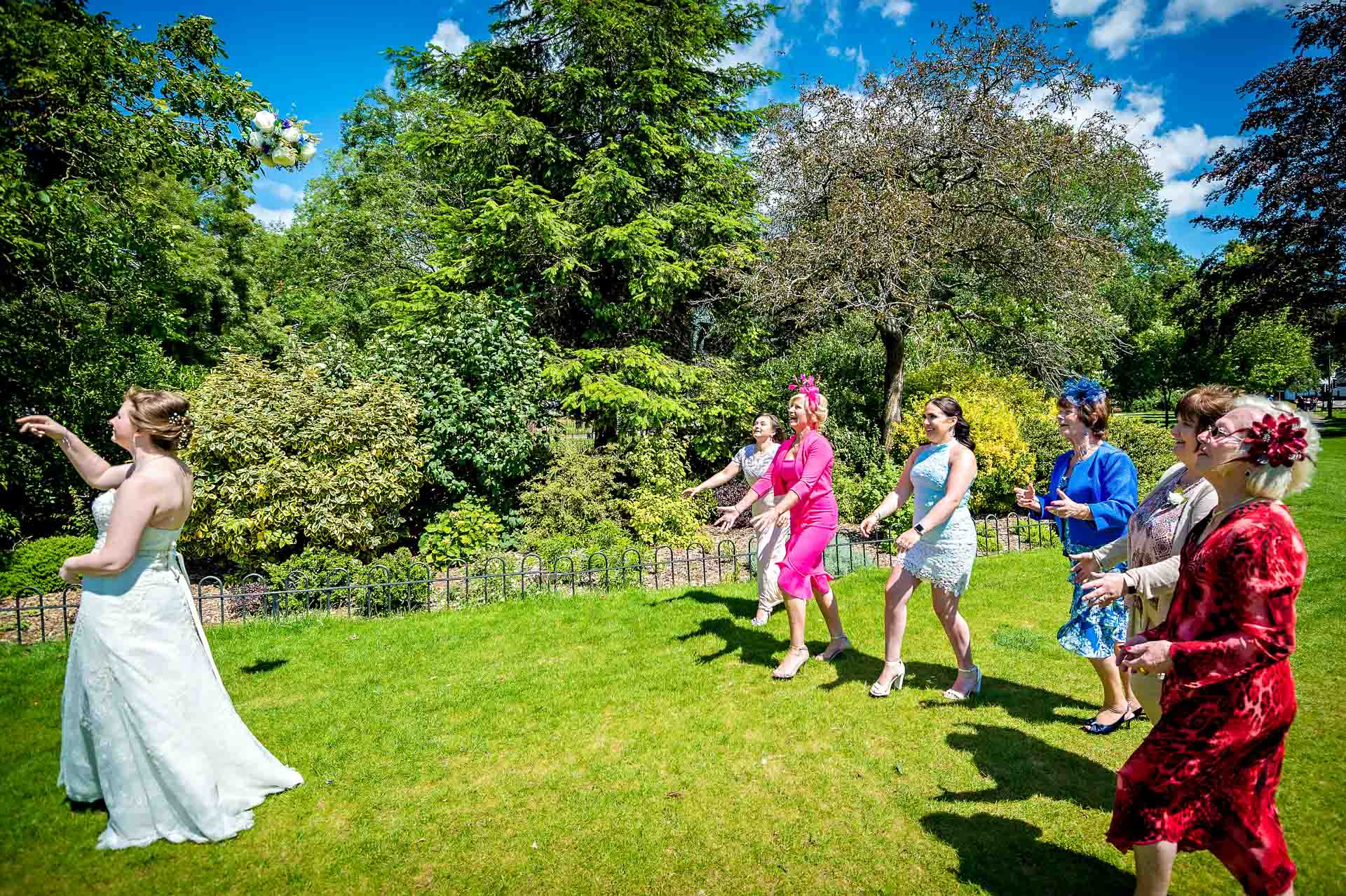 Bride throwing bouquet outside City Hall in Cardiff