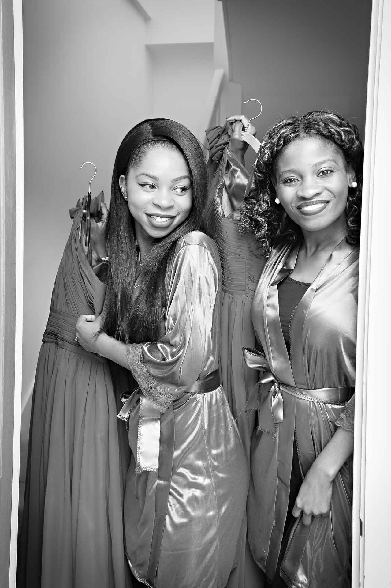 Bridesmaids holding dresses and looking through doorway