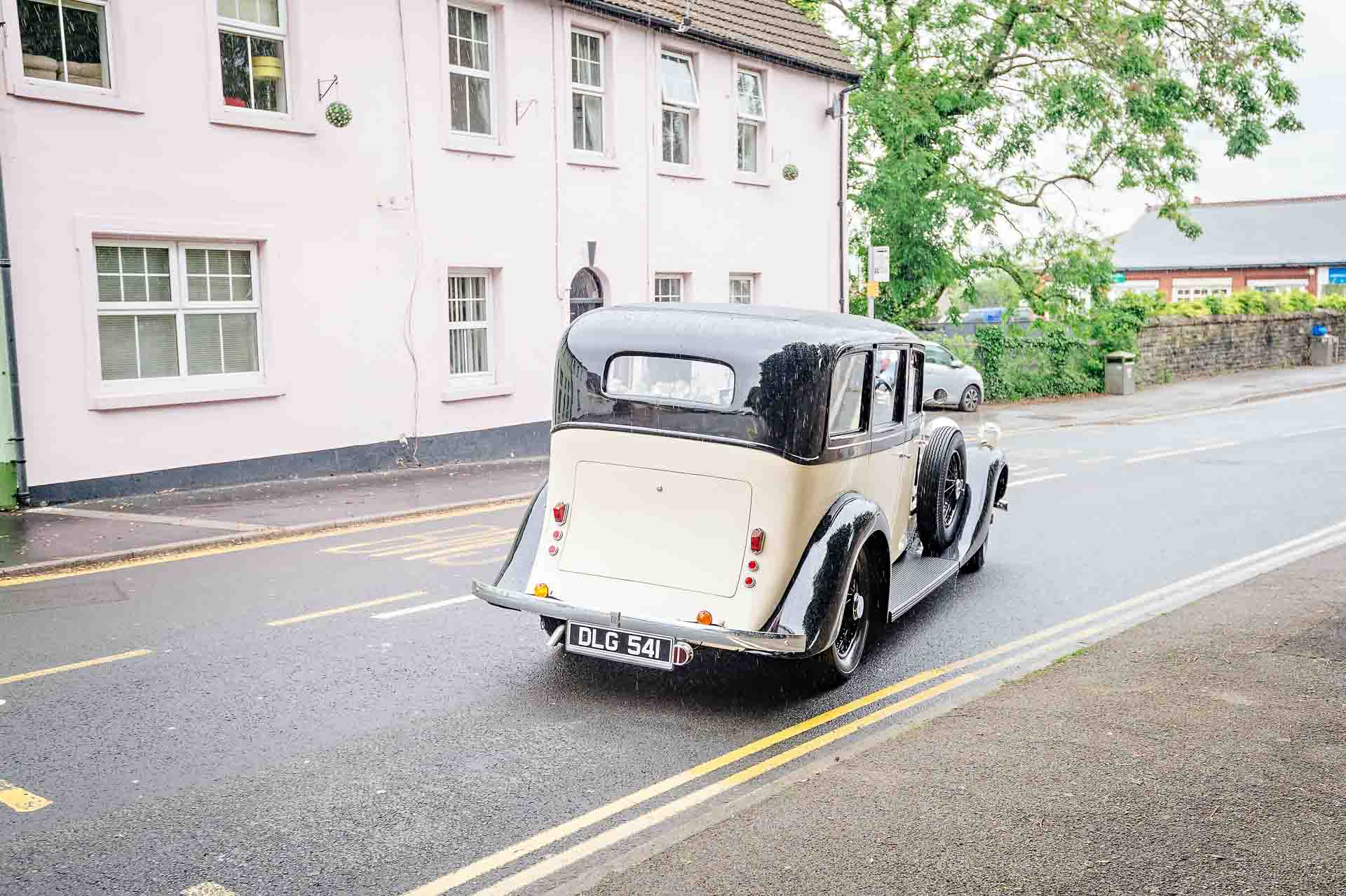 Rolls Royce pulling away from kerb from back at Caerphilly wedding
