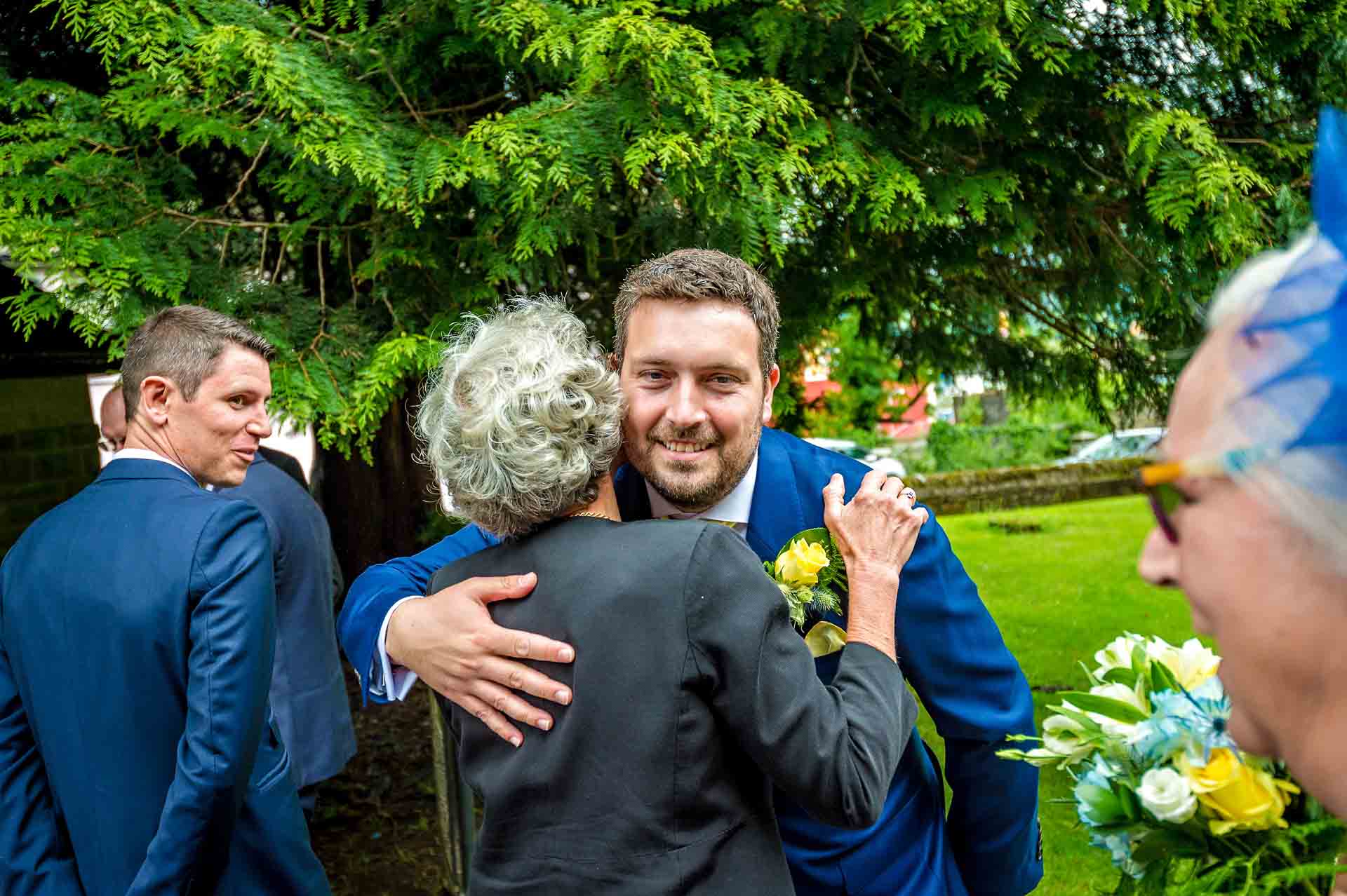 Groom hugging female relative at wedding in Caerphilly, South Wales