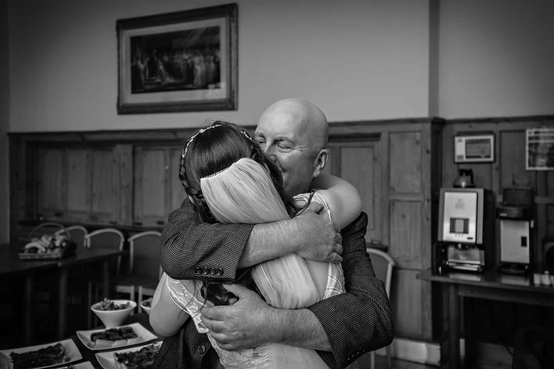 Bride hugging father at wedding reception in Bristol