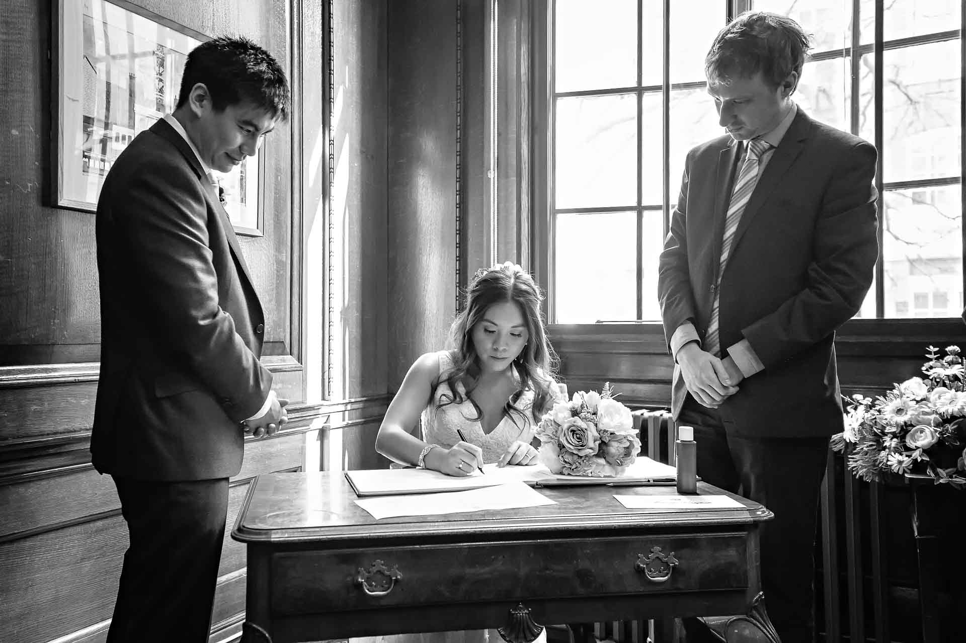 Civil Partnership at Camden Town Hall Bride Signing the Register at Camden Town Hall Wedding