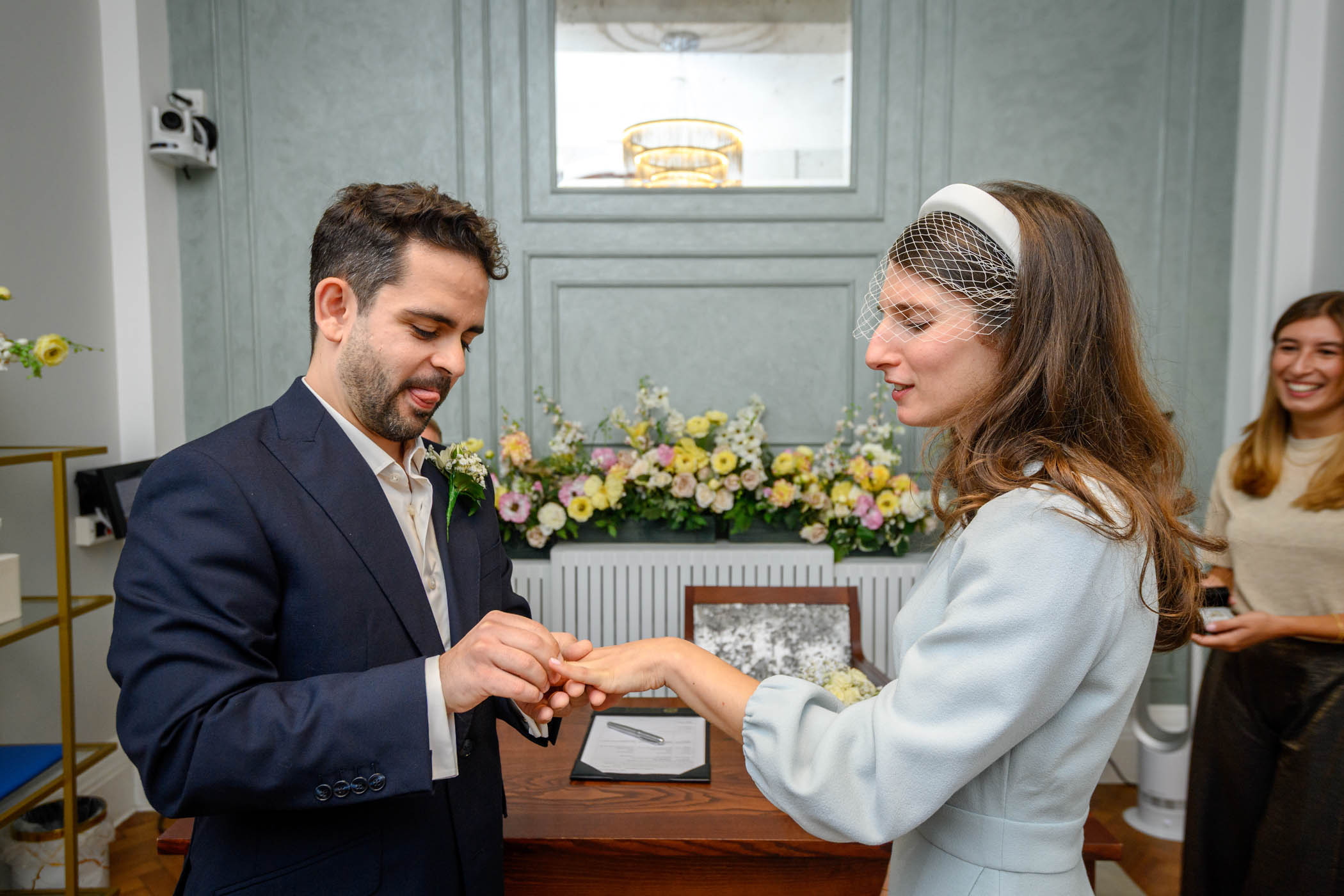 Groom placing ring on bride's finger